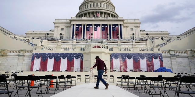 A worker pulls cables as preparations take place for President-elect Joe Biden's inauguration ceremony at the U.S. Capitol in Washington.  Some school districts choose not to live stream the ceremony to classrooms due to concerns about potential violence.  (AP Photo / Patrick Semansky)