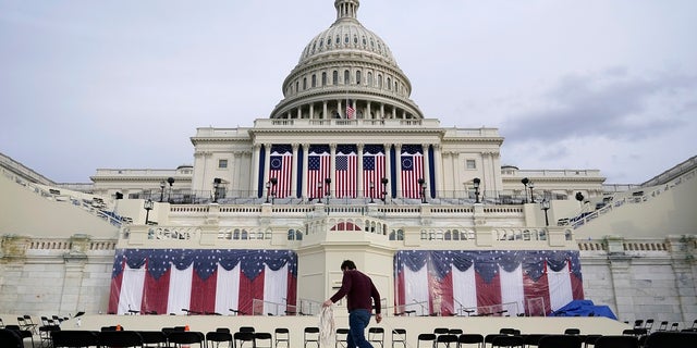 A worker pulls cables as preparations take place for President-elect Joe Biden's inauguration ceremony at the U.S. Capitol in Washington. Some school districts are electing not to live-stream the ceremony in classrooms over concerns about potential violence. (AP Photo/Patrick Semansky)