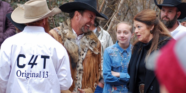 FILE - In this March 12, 2019, file photo, Cowboys for Trump leader and Otero County Commissioner Couy Griffin, center, talks with Republican New Mexico state Rep. Candy Ezzell of Roswell, N.M., at a protest against gun control and pro-abortion rights legislation outside the New Mexico State Capitol, in Santa Fe, N.M. A New Mexico county official who runs a group called "Cowboys for Trump" who had vowed to return to Washington after last week's riot at the U.S. Capitol to place a flag on House Speaker Nancy Pelosi's desk was arrested by the FBI on Sunday, Jan. 17, 2021. Griffin was arrested on charges of illegally entering the U.S. Capitol. (AP Photo/Morgan Lee, File)
