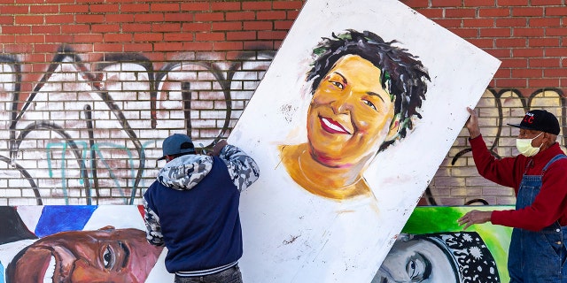 Artists set up a painting of Stacey Abrams in the King Historic District on Monday, Jan. 18, 2021, in honor of Martin Luther King Jr. Day, in Atlanta. (Associated Press)