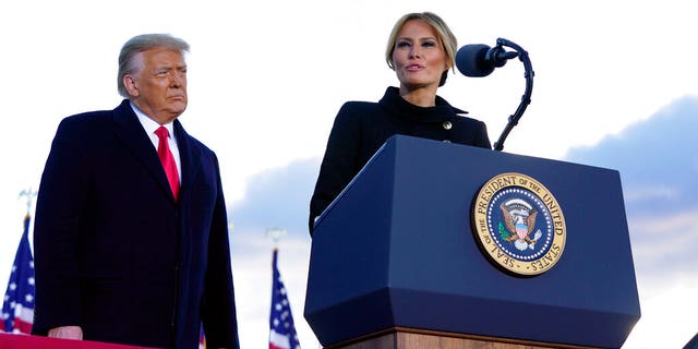 President Donald Trump listens as First Lady Melania Trump speaks before boarding Air Force One at Andrews Air Force Base, Md., Wednesday, Jan. 20, 2021.(AP Photo/Manuel Balce Ceneta)