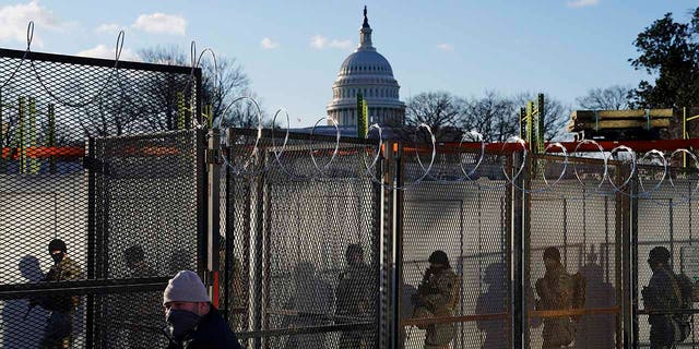 National Guards walk to the Capitol Building as events get underway for President-elect Joe Biden's inauguration ceremony, Wednesday, Jan. 20, 2021, in Washington. (AP Photo/John Minchillo)