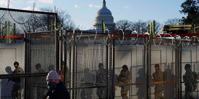 National Guards walk to the Capitol Building as events get underway for President-elect Joe Biden's inauguration ceremony, Wednesday, Jan. 20, 2021, in Washington. (AP Photo/John Minchillo)