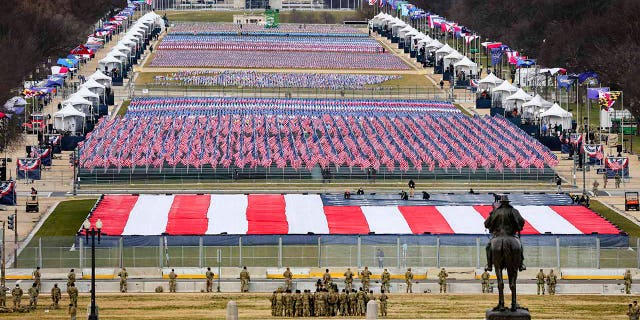 Members of the National Guard look on as American flags decorate the "Field of Flags" at the National Mall ahead of President-elect Joe Biden's inauguration ceremony, Wednesday, Jan. 20, 2021, in Washington. (Tasos Katopodis/Pool Photo via AP)
