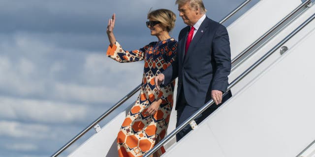 Former President Donald Trump and Melania Trump wave as they disembark from their final flight on Air Force One at Palm Beach International Airport in West Palm Beach, Fla., Wednesday, Jan. 20, 2021. (AP Photo/Manuel Balce Ceneta)