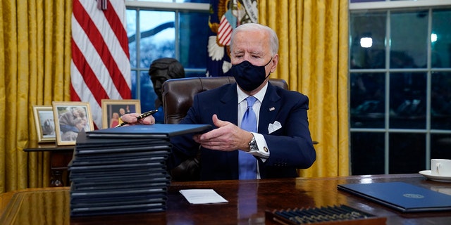 President Joe Biden signs his first executive orders, including one canceling the Keystone XL pipeline's federal permits, in the White House on Jan. 20, 2021.