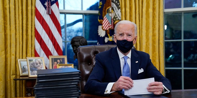 President Biden pauses as he signs his first executive orders at the White House on Jan. 20, 2021.