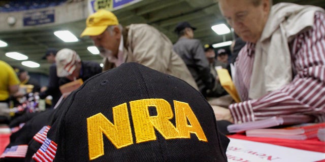 FILE - This photo from Wednesday March 7, 2012, shows Illinois gun owners and supporters file NRA applications during an Illinois Gun Owners Lobby Day convention before marching to the Illinois State in Springfield, Ill. (AP Photo/Seth Perlman, File)