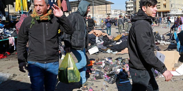 People and security forces gather at the site of a deadly bomb attack in Baghdad, Iraq, Thursday, Jan. 21, 2021.
