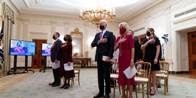 Doug Emhoff, left, Vice President Kamala Harris, President Joe Biden, and first lady Jill Biden, stand during a performance of the national anthem during a virtual Presidential Inaugural Prayer Service. (AP Photo/Alex Brandon)
