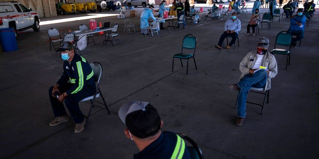 Farmworkers wait in the holding area after getting the Pfizer-BioNTech COVID-19 vaccine at Tudor Ranch in Mecca, Calif., Thursday, Jan. 21, 2021.