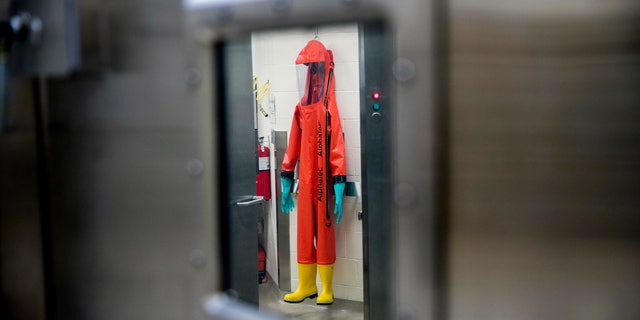 FILE - In this March 19, 2020, file photo, a biosafety protective suit for handling viral diseases are hung up in a biosafety level 4 training facility at U.S. Army Medical Research and Development Command at Fort Detrick in Frederick, Md., where scientists are working to help develop solutions to prevent, detect and treat the coronavirus. China is trying to spread doubt about the effectiveness of Western vaccines and the origin of the coronavirus as a World Health Organization-selected team of scientists are in the city where the pandemic first broke out. (AP Photo/Andrew Harnik, File)