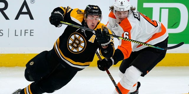 Boston Bruins center Brad Marchand (63) and Philadelphia Flyers defenseman Travis Sanheim (6) skate for position during the third period of an NHL hockey game Thursday, Jan. 21, 2021, in Boston. (AP Photo/Elise Amendola)