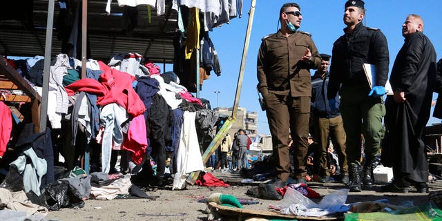FILE: Security forces work at the site of a deadly bomb attack in a market selling used clothes, in Baghdad, Iraq.