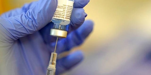 A pharmacist prepares a syringe of the Pfizer-BioNTech COVID-19 vaccine Friday, Jan. 8, 2021, at Queen Anne Healthcare, a skilled nursing and rehabilitation facility in Seattle.  (AP Photo/Ted S. Warren)