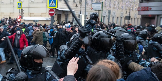 Police officers clash with people during a protest against the jailing of opposition leader Alexei Navalny in Moscow, Russia, Saturday, Jan. 23, 2021. Russian police on Saturday arrested hundreds of protesters who took to the streets in temperatures as low as minus-50 C (minus-58 F) to demand the release of Alexei Navalny, the country's top opposition figure. (AP Photo/Pavel Golovkin)