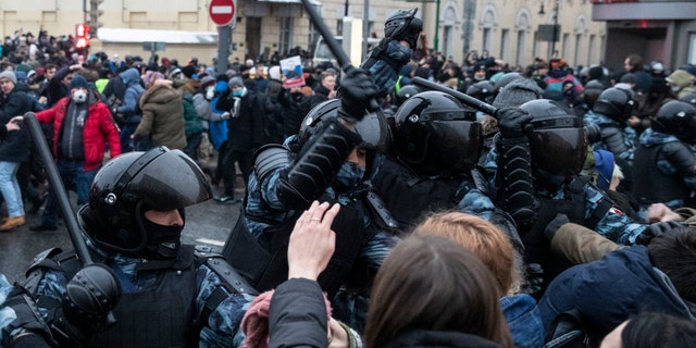 Police officers clash with people during a protest against the jailing of opposition leader Alexei Navalny in Moscow, Russia, Saturday, Jan. 23, 2021. Russian police on Saturday arrested hundreds of protesters who took to the streets in temperatures as low as minus-50 C (minus-58 F) to demand the release of Alexei Navalny, the country's top opposition figure. (AP Photo/Pavel Golovkin)
