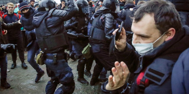 Police clash with demonstraters during a protest against the jailing of opposition leader Alexei Navalny in People gather in St.Petersburg, Russia, Saturday, Jan. 23, 2021. Russian police are arresting protesters demanding the release of top Russian opposition leader Alexei Navalny at demonstrations in the country's east and larger unsanctioned rallies are expected later Saturday in Moscow and other major cities. (AP Photo/Dmitri Lovetsky)