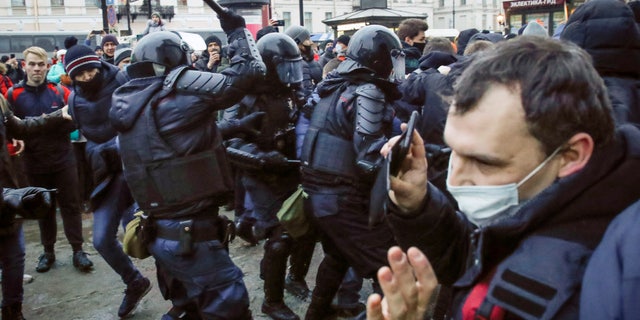 Police clash with demonstraters during a protest against the jailing of opposition leader Alexei Navalny in People gather in St.Petersburg, Russia, Saturday, Jan. 23, 2021. Russian police are arresting protesters demanding the release of top Russian opposition leader Alexei Navalny at demonstrations in the country's east and larger unsanctioned rallies are expected later Saturday in Moscow and other major cities. (AP Photo/Dmitri Lovetsky)