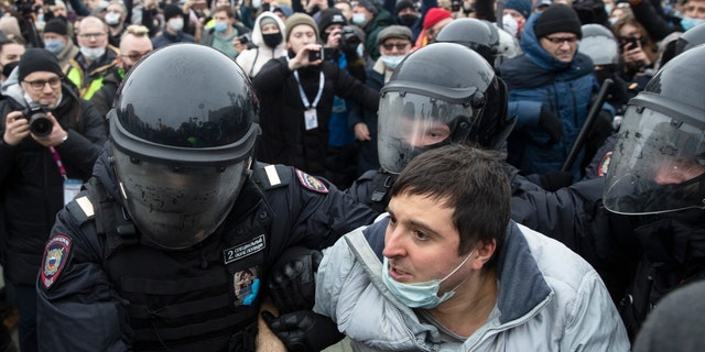 Police officers detain a man during a protest against the jailing of opposition leader Alexei Navalny in Moscow, Russia, Saturday, Jan. 23, 2021. Russian police on Saturday arrested hundreds of protesters who took to the streets in temperatures as low as minus-50 C (minus-58 F) to demand the release of Alexei Navalny, the country's top opposition figure. (AP Photo/Pavel Golovkin)