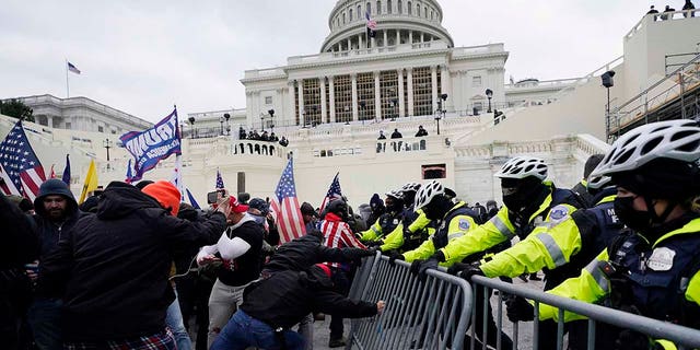 In this Wednesday, Jan. 6, 2021 file photo, Trump supporters try to break through a police barrier at the Capitol in Washington. (AP Photo/Julio Cortez, File)
