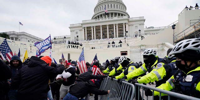 In this Wednesday, Jan. 6, 2021 file photo, Trump supporters try to break through a police barrier at the Capitol in Washington. (AP Photo/Julio Cortez, File)