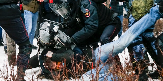 Riot police detain a demonstrator with a bloody face during a protest against the jailing of opposition leader Alexei Navalny in Pushkin square in Moscow, Russia, Saturday, Jan. 23, 2021. (AP Photo/Alexander Zemlianichenko)