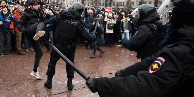 A demonstrator clashes with a police officer during a protest against the jailing of opposition leader Alexei Navalny in Pushkin square in Moscow, Russia, Saturday, Jan. 23, 2021. (AP Photo/Victor Berezkin)