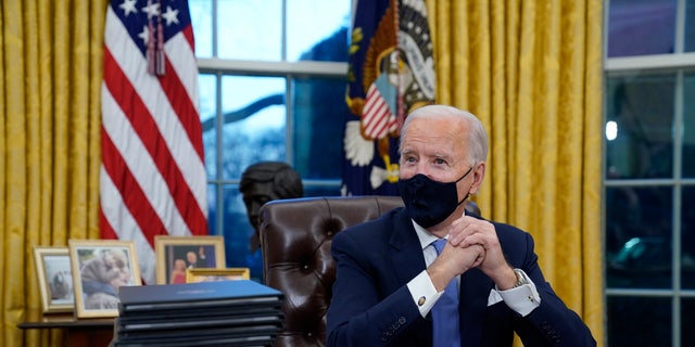 President Joe Biden signs his first executive orders, including revoking federal permits to build the Keystone XL pipeline, at the White House on January 20, 2021.