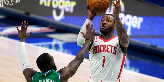 Dallas Mavericks forward Tim Hardaway Jr. (11) defends against a shot by Houston Rockets guard John Wall (1) during the second half of an NBA basketball game in Dallas, Saturday, Jan. 23, 2021. (AP Photo/Tony Gutierrez)