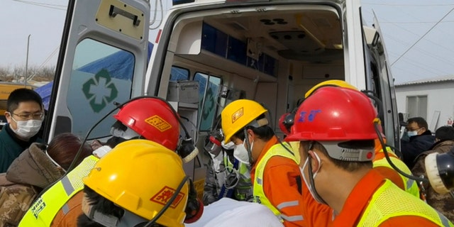 In this photo released by Xinhua News Agency, rescuers carry a miner who was trapped in a gold mine in Qixia City in east China's Shandong Province, Sunday, Jan. 24, 2021. Rescuers in China on Sunday lifted several trapped miners to the surface who were trapped for two weeks after an explosion in a northern gold mine, state media reported. (Luan Qincheng/Xinhua via AP)