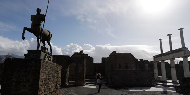 A journalist takes pictures in the archeological site of Pompeii during the inauguration of the museum Antiquarium, in Pompeii, southern Italy, Monday, Jan. 25, 2021. (AP Photo/Gregorio Borgia)