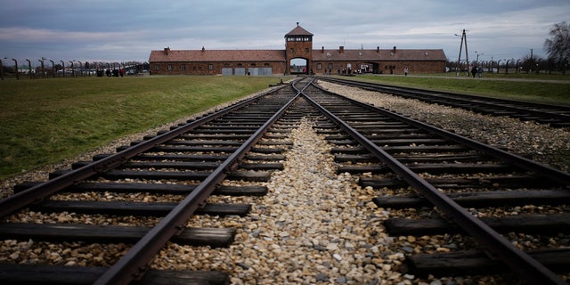 FILE - In this Saturday, Dec. 7, 2019 photo the railway tracks where hundred thousands of people arrived to be directed to the gas chambers inside the former Nazi death camp of Auschwitz Birkenau, or Auschwitz II, are pictured in Oswiecim, Poland. (AP Photo/Markus Schreiber, file)