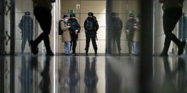 Police stand guard at the Foundation for Fighting Corruption office in Moscow, Russia, Wednesday, Jan. 27, 2021. Police are searching the Moscow apartment of jailed Russian opposition leader Alexei Navalny, another apartment where his wife is living and two offices of his anti-corruption organization. Navalny's aides reported the Wednesday raids on social media. (AP Photo/Pavel Golovkin)