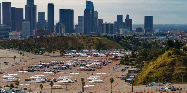 Drivers wait in line at a mega COVID-19 vaccination site set up in the parking lot of Dodger Stadium in Los Angeles, 星期三, 一月. 27, 2021.