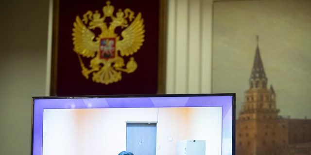 Russian opposition leader Alexei Navalny appears on a TV screen during a live session with the court during a hearing of his appeal, in Moscow, Russia, Thursday, Jan. 28, 2021. Navalny was jailed soon after arriving to Moscow after authorities accused him of violating of the terms of his 2014 fraud conviction. A court on Thursday is to hear an appeal on the ruling to remand him into custody. Next week, another court will decide whether to send him to prison for several years for the alleged violations. (AP Photo/Pavel Golovkin)