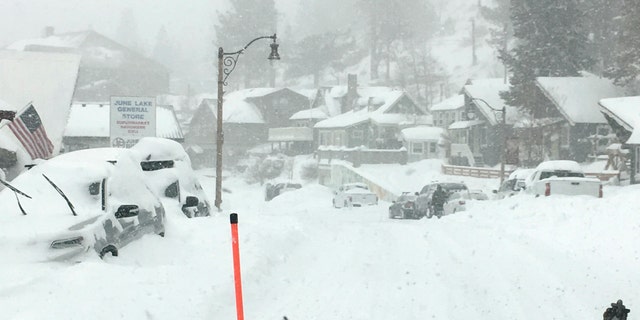 In this photo provided by Caltrans District 9, heavy snowfall blankets car at June Lake, in Mono County on Wednesday, 一月. 27, 2021. An atmospheric river storm pumped drenching rains into the heart of California on Thursday as blizzard conditions buried the Sierra Nevada in snow. (Randy Walker/Caltrans District 9 via AP)