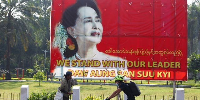 A cyclist bikes past a signboard with an image of Burma leader Aung San Suu Kyi, in Yangon, Burma Friday, Jan. 29, 2021. 