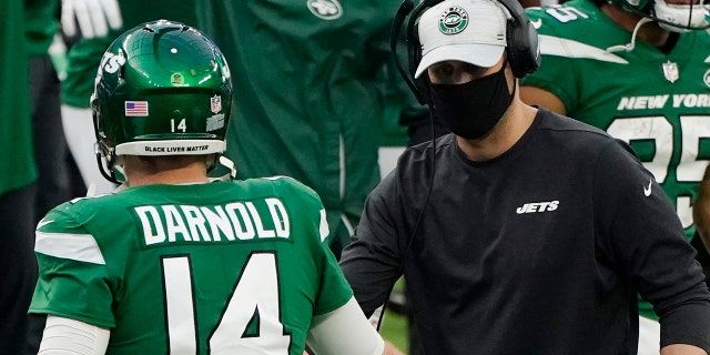 New York Jets head coach Adam Gase shakes hands with quarterback Sam Darnold (14) after the Jets scored a touchdown during the second half of an NFL football game against the Los Angeles Rams Sunday, Dec. 20, 2020, in Inglewood, Calif. (AP Photo/Ashley Landis)