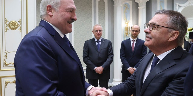 Belarusian President Alexander Lukashenko, left, greets International Ice Hockey Federation President Rene Fasel during their meeting in Minsk, Belarus, Monday, Jan. 11, 2021. White House Press Secretary Jen Psaki denied Lukashenko's allegation that the U.S. was behind a plot to assassinate him. (Nikolai Petrov/BelTA Pool Photo via AP)