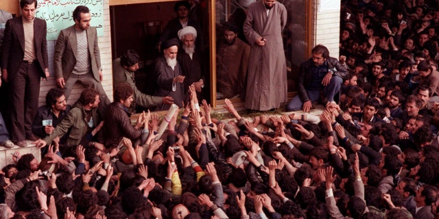 Ayatollah Ruhollah Khomeini is greeted by supporters after arriving at the airport in Tehran Iran, on Feb. 1, 1979. (AP Photo)