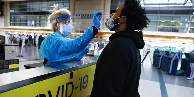 A man receives a nasal swab COVID-19 test at Tom Bradley International Terminal at Los Angeles International Airport (LAX).