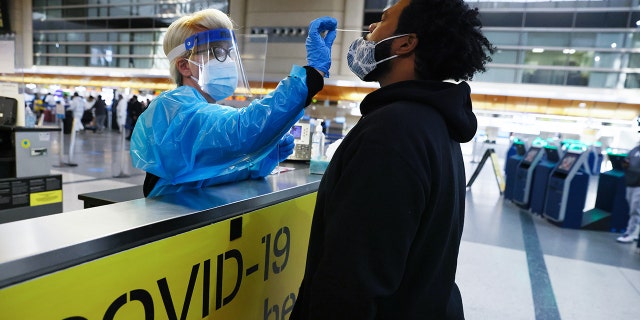 A man receives a nasal swab COVID-19 test at Tom Bradley International Terminal at Los Angeles International Airport (LAX).