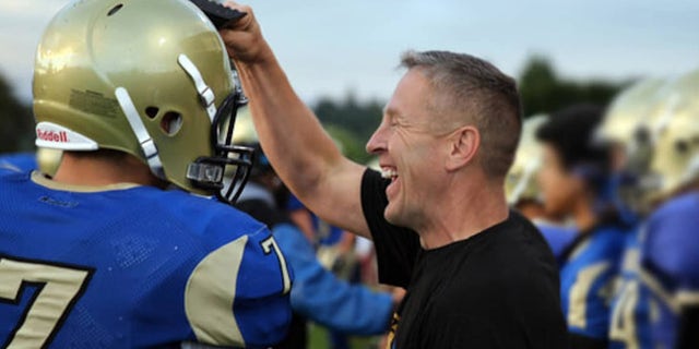 Joe Kennedy, who coached high school football in Bremerton, 华盛顿州, with his players on the field