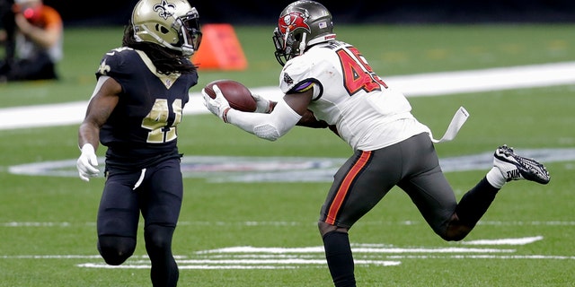 Tampa Bay Buccaneers in lineout player Devin White, right, intercept a pass in front of New Orleans Saints, who runs back Alvin Kamara, 41, during the second half of an NFL division round playoff game on Sunday, January 17, 2021, in New Orleans.  .  (AP Photo / Brett Duke)