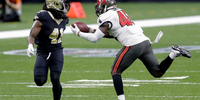 Tampa Bay Buccaneers inside linebacker Devin White, right, intercepts a pass past New Orleans Saints running back Alvin Kamara (41) during the second half of a divisional round playoff football game the NFL, Sunday, January 17, 2021, in New Orleans.  (AP Photo / Brett Duke)