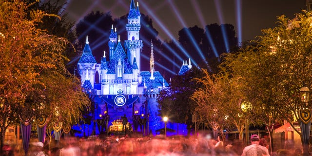 Disneyland 60th anniversary castle with people walking