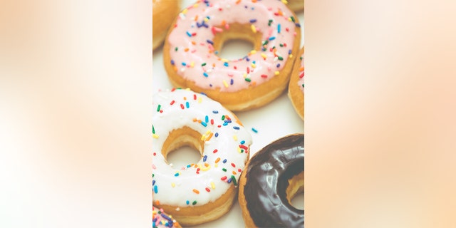 A variety of donuts are shown close up. Dunkin today has 12,600 donut shops in 40 countries, including 8.500 in the U.S. alone. 