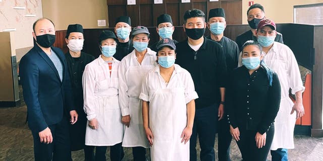 Restaurant staff at Douzo Sushi in Boston posed for a team photo, which was shared in an Instagram announcement post detailing the employee benefits they have received throughout the COVID-19 pandemic. (Douzo Sushi)