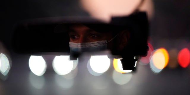 Emergency medical technician Joshua Hammond, 25, of Emergency Ambulance Service, drives an ambulance to his station in Placentia, Calif. Friday, Jan. 8, 2021. (AP Photo/Jae C. Hong)